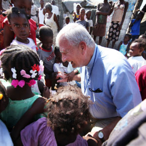 The late Fr. Richard Martin talked with children while he was on a mission trip to Haiti