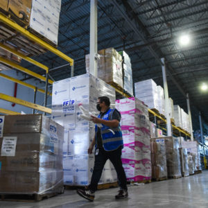 A Food For The Poor team member walks by pallets of relief supplies in the organization's warehouse.