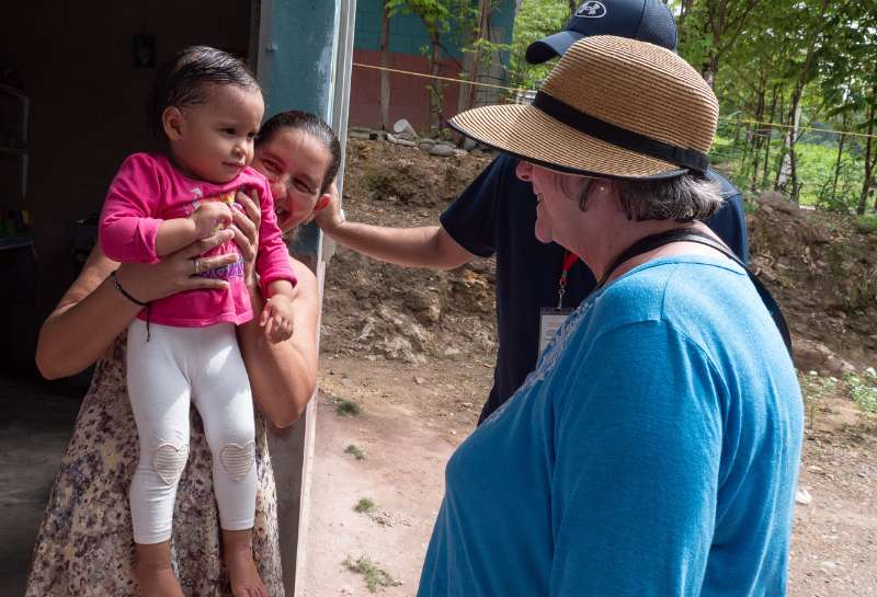 Visitors on a mission trip to Honduras visit a family in their home 