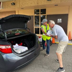 People loading the trunk of a car that will deliver relief supplies to those affected by Hurricane Milton