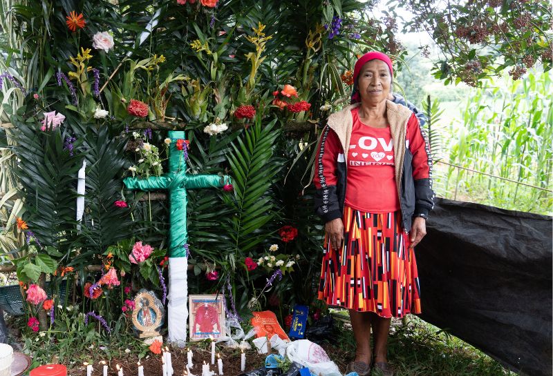 A Lenca woman stands next to an altar made for La Compostura, a Lenca tradition
