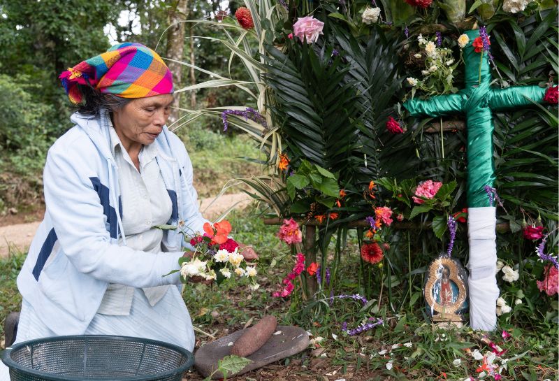 A Lenca woman prepares the altar with flowers for La Compostura, a Lenca tradition