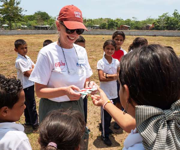 Woman hands out gifts to children on a mission trip