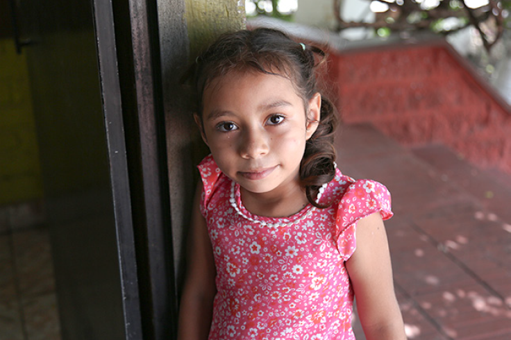 A young girl smiling in the doorway 