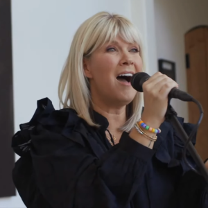 Christian recording artist Natalie Grant holding a microphone and singing.