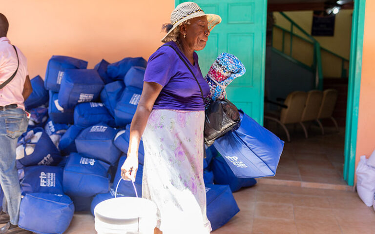 a women carries a bag of emergency supplies made possible by year-end giving