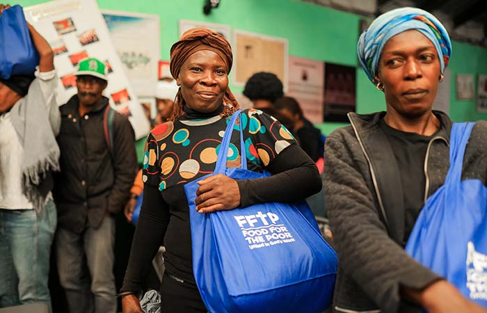 A woman holds a bag of goods provided by Food For The Poor, a qualifying charity, how to deduct donations in 2026