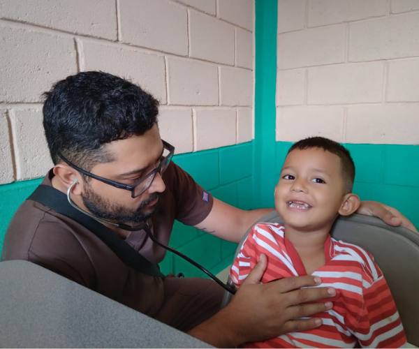 Young boy with access to healthcare getting his heart checked by a doctor with a stethoscope