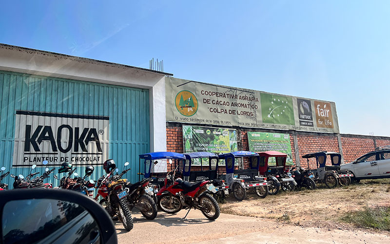 Motorcycles and mototaxis parked outside of Kaoka, the chocolate plant in Peru