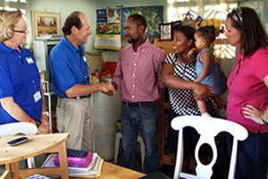 Hope For Haitians Chairmen, Ben and Louise Scott (L), along with Food For The Poor's Haiti Projects Manager, Beth Carroll (R), visits the Louie family in Michaud. The Louie family were relocated from a tent city and given a home in Boca Grande's Friendship Village II.