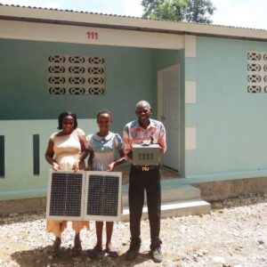 Haitian family stands outside of their new home funded by Boca Grande hope for Haitians Committee