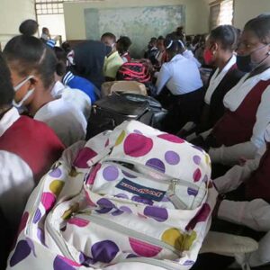 Rows of students sit close together in a crowded classroom in Haiti.