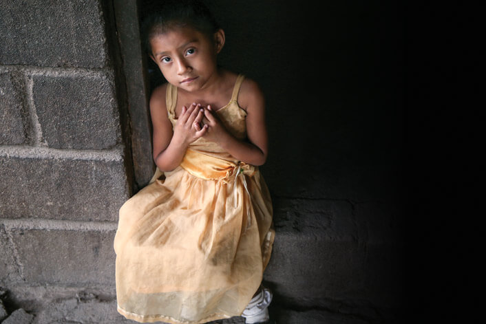 a young girl in a yellow dress waiting for relief