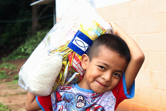 El Salvador - Kid holding plastic bag with food