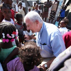 The late Fr. Richard Martin of Nativity Catholic Church stands surrounded by people of Haiti, the parish will receive the cornerstone award for their help to vulnerable families