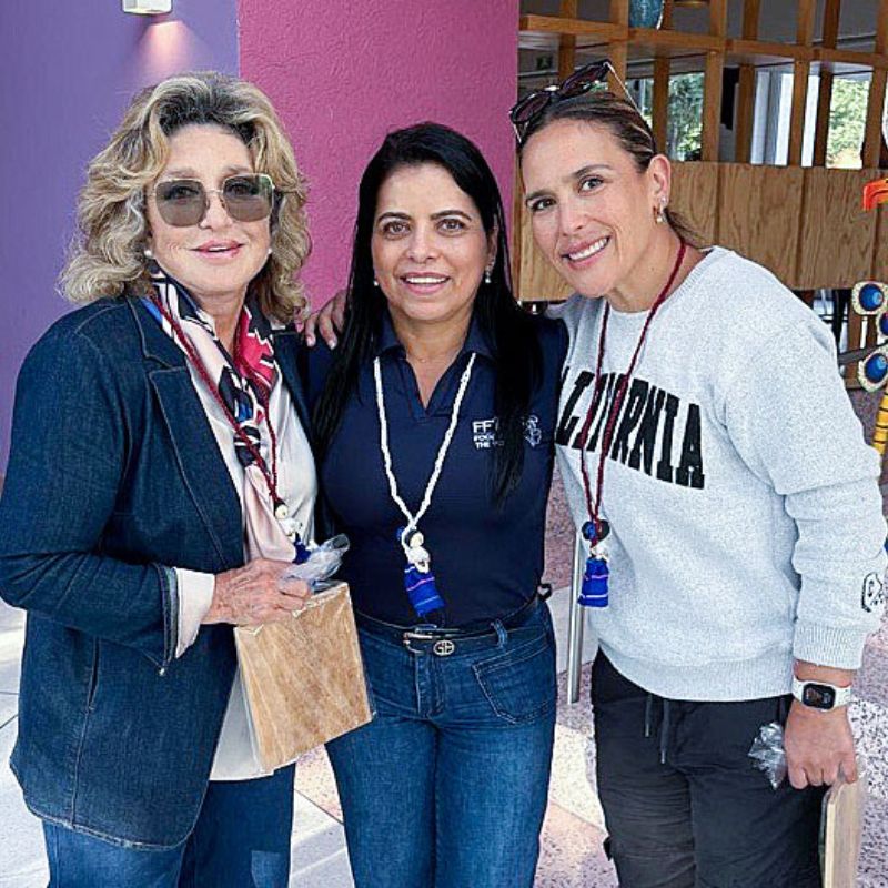 three women standing together and smiling