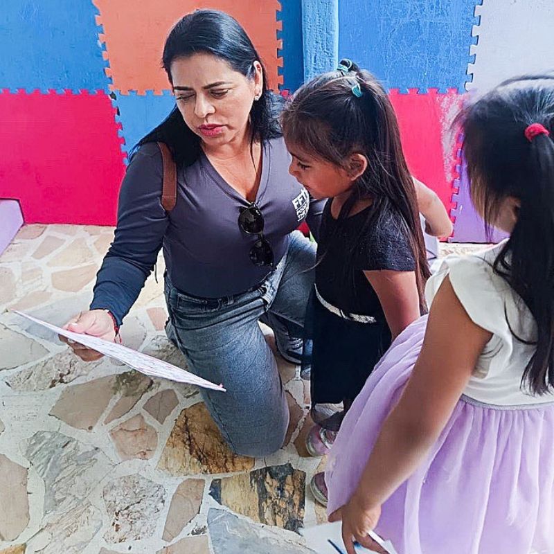a woman reads a message given to her by two young girls