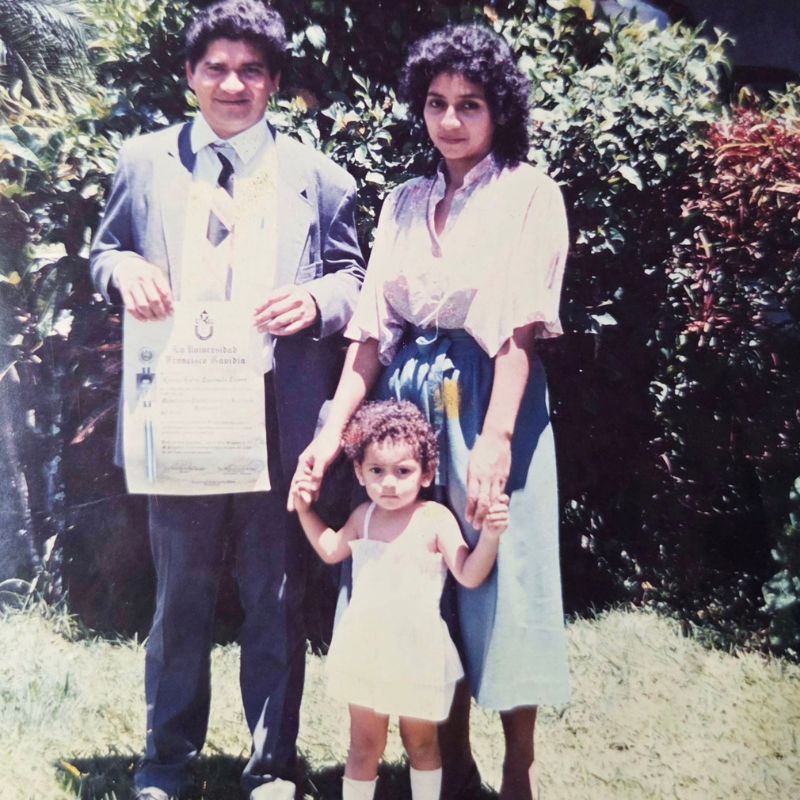 A photo of a father, mother, and child standing outside