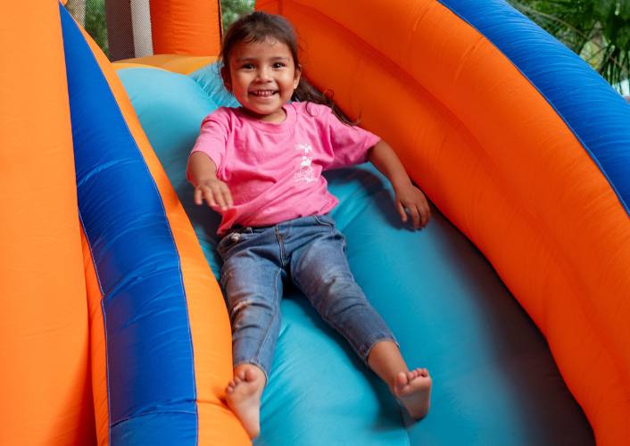 A young girl smiling on an inflatable slide fftp's hope fest activities