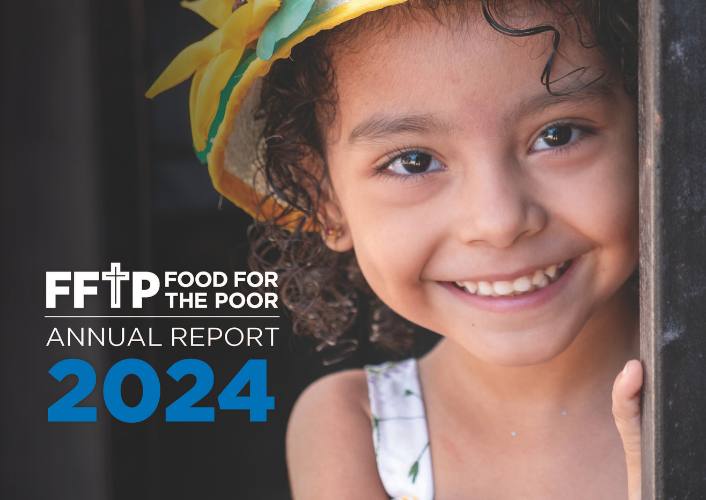 A young girl smiles on the cover of the Food For The Poor Annual Report