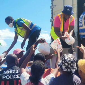 Relief supplies being handed out to a crowd of people as part of food for the poor jamaica relief after hurricane Melissa