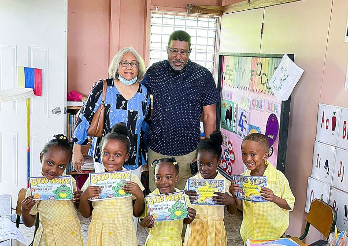 Founders of Christos Ministries stand with children in a school they built with Food For The Poor