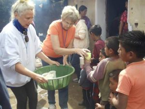 Travelers hand out drinks to children during a mission trip to rural Guatemala.