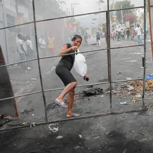 A woman steps through a barricade in Port-au-Prince, Haiti.