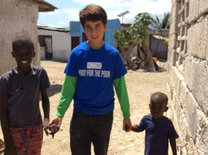 Georgos Jusakos, 13, of Orlando, holds the hands of two boys in Alpha Village, Haiti. Jusakos traveled to Haiti in August with Food For The Poor and a group of donors from Orlando and Palm Beach County. (Photo/Food For The Poor)