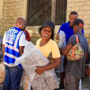 Haitian woman smiles as she receives food from FFTP employees