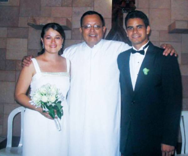 Jesus and his wife Yallie stand with a priest after renewing their vows