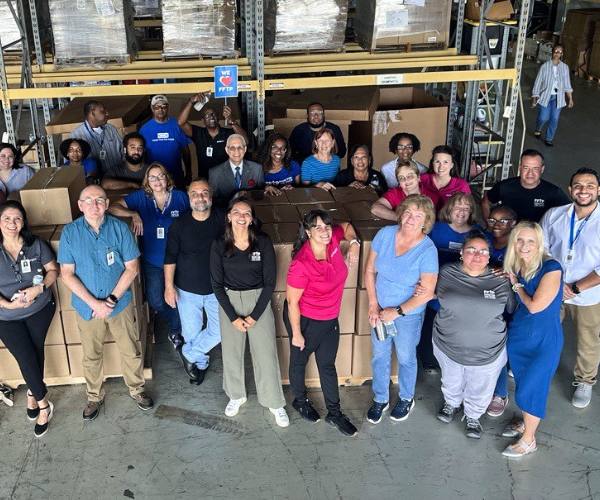 Ana Duarte stands with her FFTP team members in the warehouse