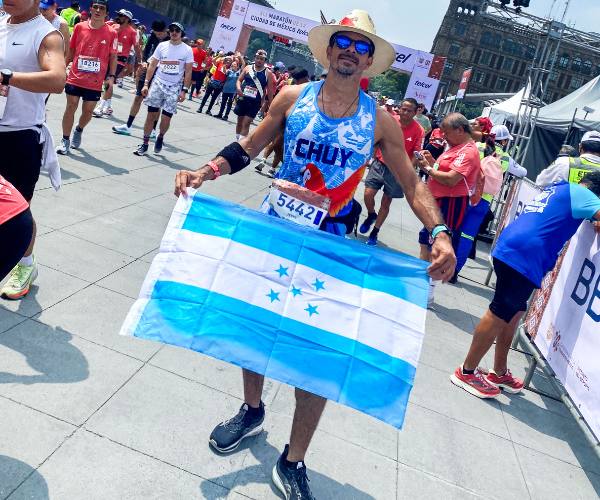 Jesus holding a Honduran flag after a marathon