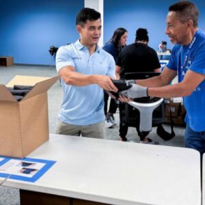 Two men help pack supplies for hurricane preparedness week at FFTP headquarters
