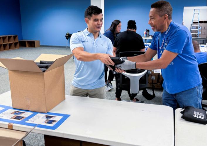 Two men help pack supplies for hurricane preparedness week at FFTP headquarters