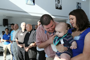Fr. Richard Martin's nephew, Eric Martin, shown here with baby, Grayson, and wife Nicole, attended the celebration of life for the priest at Food For The Poor headquarters in Coconut Creek, Fla.