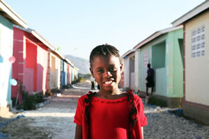 A girl walks through the newly inaugurated Journey of Hope Village, outside Port-au-Prince, Haiti. Food For The Poor has built 3,668 two-room concrete block homes since the 2010 earthquake.