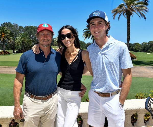 Rafe Cochran poses for a photo with his parents on a golf course