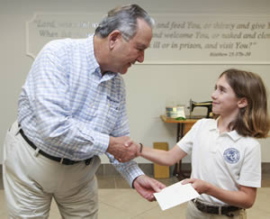 Rafe Cochran, 9, presented a $6,000 check to Food For The Poors CEO/President Robin Mahfood on Wednesday.
