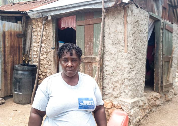 Haitian woman stands in front of her crumbling home as FFTP works to bring safe homes to Haiti