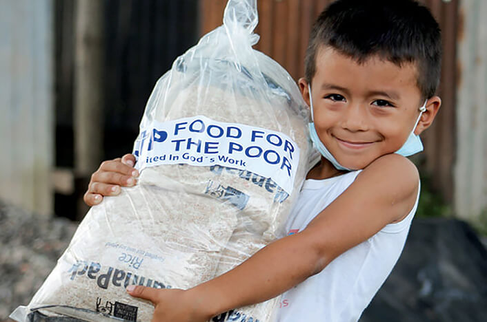A young boy carrying a fftp relief package