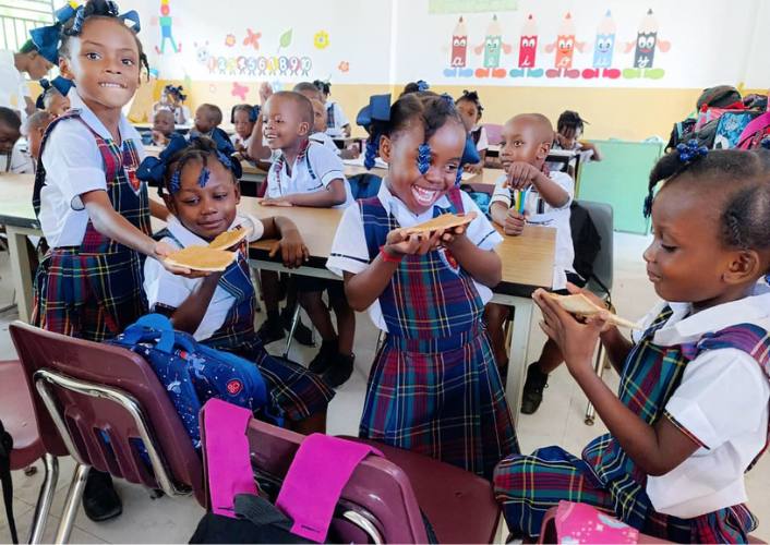 Haitian girls eating breakfast at school thanks to FFTP Shine program for World Food Day