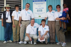 Eight 4 World Hope representatives (kneeling) Kevin and Jacqueline Carges, (l-r) Greg Emerton, Catherine Metzger, Terry Leathersich, Laurie D'Amico and Karen Donoghue traveled with Food For The Poor to McCook's Pen, St. Catherine,  Jamaica, in February for the dedication and inauguration of the High House Basic School.