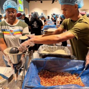 two people at a station, working together to pack rice in a bag